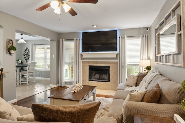 628 Destin Dr, Fort Worth, TX 76131 - living area with a ceiling fan, wood finished floors, a tiled fireplace, and baseboards