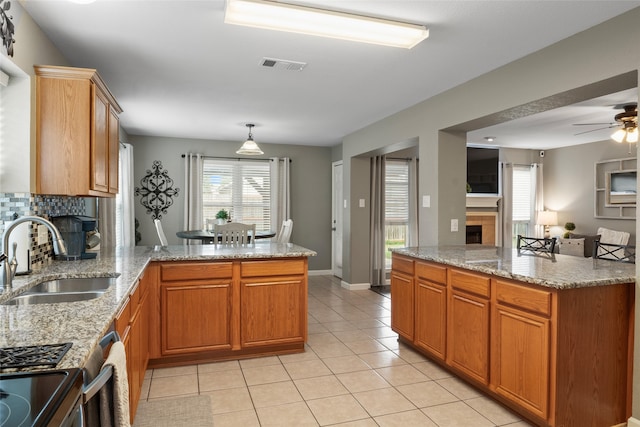 kitchen featuring sink, light stone countertops, pendant lighting, and light tile patterned floors