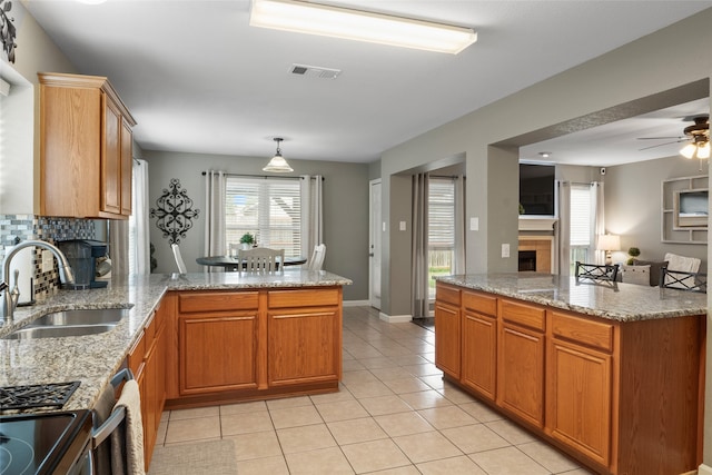 628 Destin Dr, Fort Worth, TX 76131 - kitchen with a fireplace, a sink, a peninsula, light tile patterned flooring, and a ceiling fan