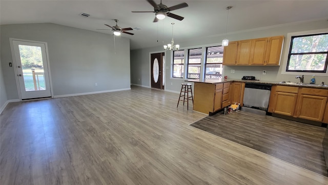 kitchen with a breakfast bar, stainless steel dishwasher, light wood-type flooring, and a wealth of natural light