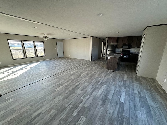 unfurnished living room featuring a textured ceiling, hardwood / wood-style flooring, and ceiling fan