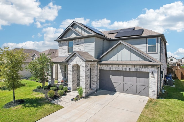 view of front of house with a garage, a front yard, and solar panels