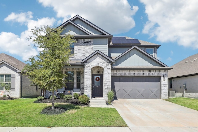 craftsman-style house with solar panels, central AC unit, a garage, and a front lawn