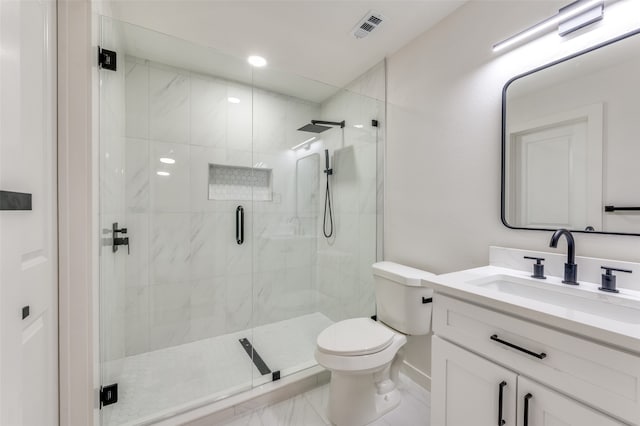 bathroom featuring toilet, a shower with shower door, and vanity