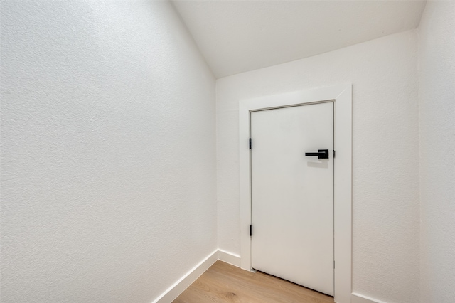 doorway with light hardwood / wood-style floors and lofted ceiling