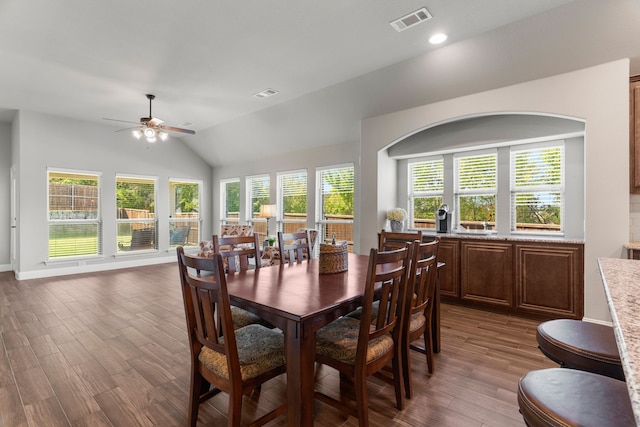 dining room featuring ceiling fan, dark wood-type flooring, and vaulted ceiling