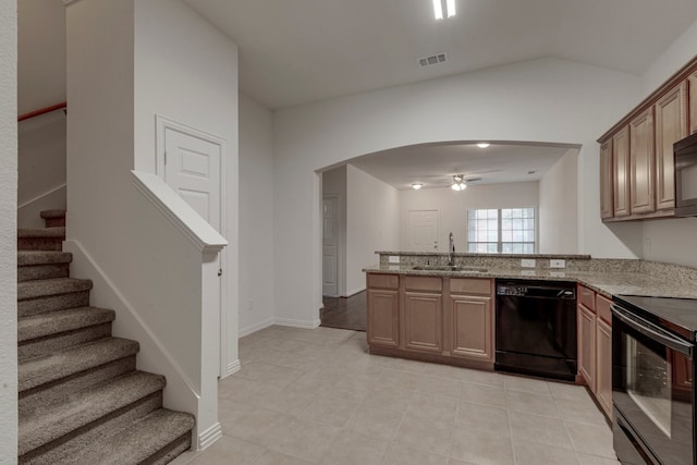 kitchen with kitchen peninsula, sink, black appliances, light stone countertops, and ceiling fan