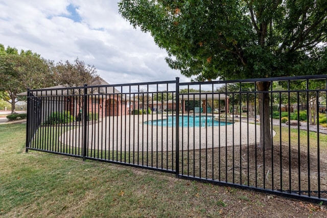 view of gate featuring a yard and a fenced in pool