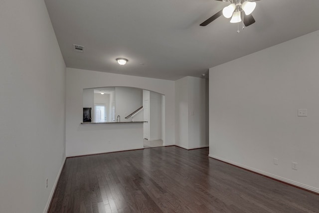 unfurnished living room with ceiling fan and dark hardwood / wood-style flooring