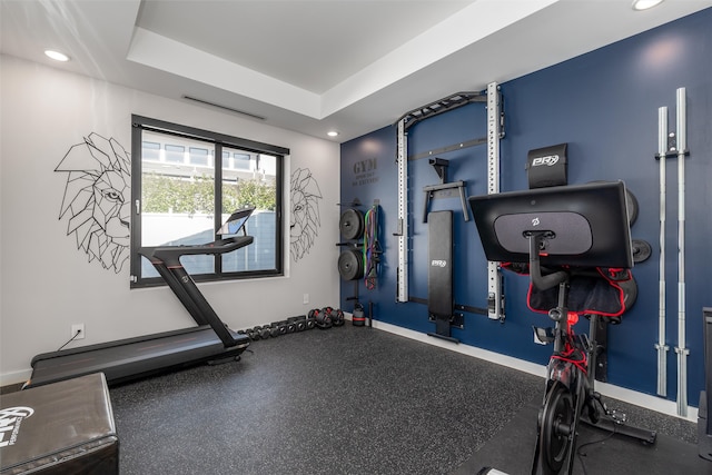 workout room with a tray ceiling