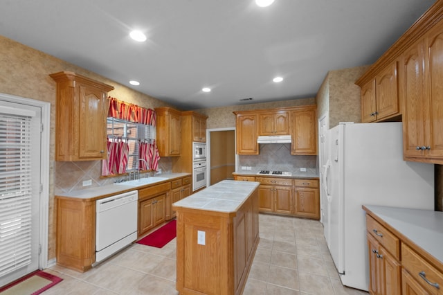 kitchen featuring white appliances, light tile patterned floors, decorative backsplash, and a center island