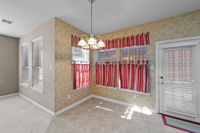 unfurnished dining area with an inviting chandelier and tile patterned flooring