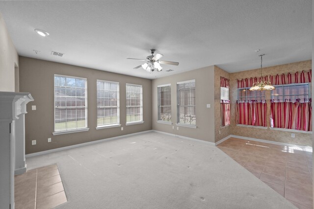 unfurnished living room with carpet flooring, a textured ceiling, and ceiling fan with notable chandelier