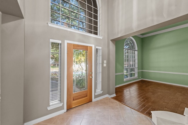 entrance foyer with a towering ceiling and light wood-type flooring