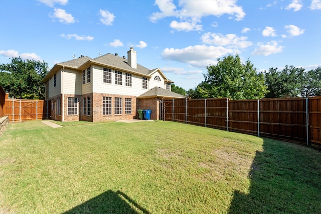 rear view of property with a yard