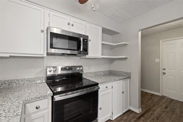 kitchen with appliances with stainless steel finishes, white cabinetry, a textured ceiling, dark wood-type flooring, and light stone counters