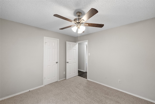 unfurnished bedroom featuring carpet, a textured ceiling, and ceiling fan