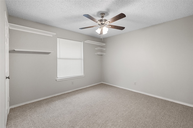 spare room featuring carpet floors, a textured ceiling, and ceiling fan