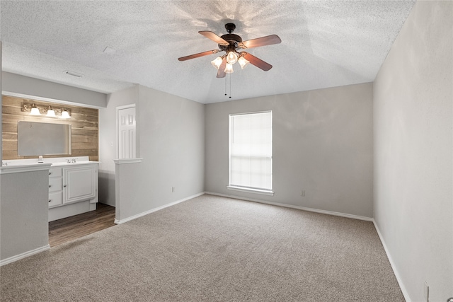 unfurnished bedroom featuring ceiling fan, a textured ceiling, and carpet floors