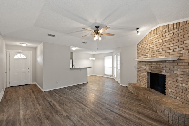 unfurnished living room with dark hardwood / wood-style floors, a textured ceiling, a fireplace, and ceiling fan