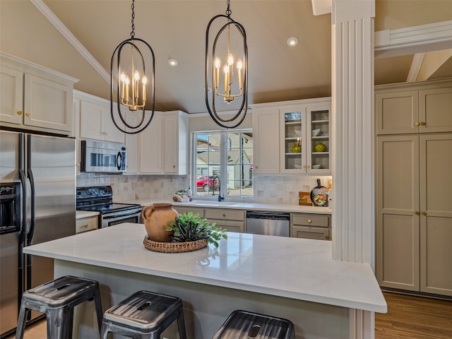 kitchen featuring a breakfast bar, light stone counters, hanging light fixtures, and appliances with stainless steel finishes