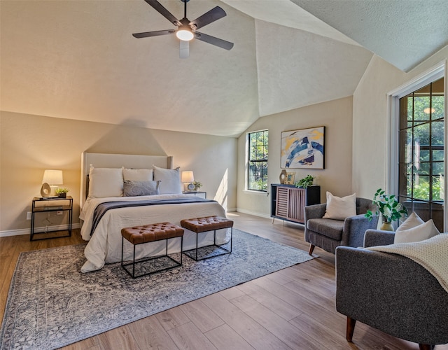 bedroom with a textured ceiling, light hardwood / wood-style floors, ceiling fan, and lofted ceiling