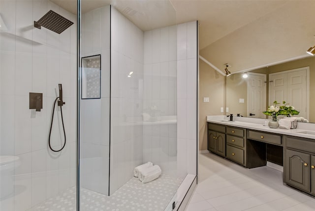 bathroom featuring a tile shower, vanity, and tile patterned floors