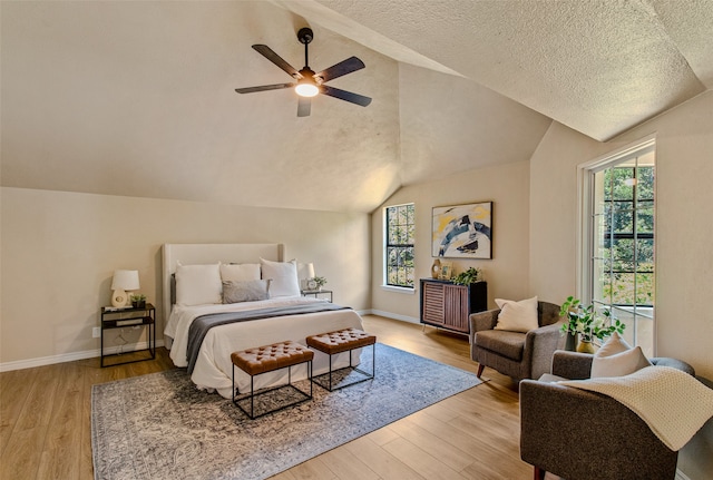 bedroom with light hardwood / wood-style floors, lofted ceiling, and multiple windows