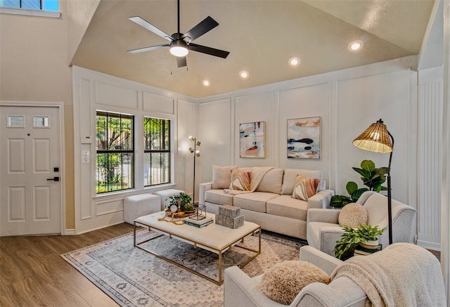 living room with hardwood / wood-style floors, high vaulted ceiling, and ceiling fan