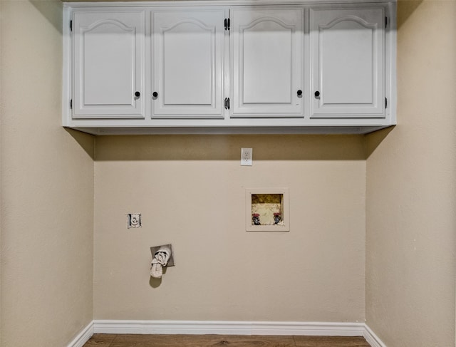 clothes washing area with cabinets and hookup for a washing machine