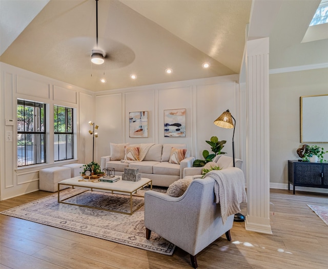 living room featuring ceiling fan, light hardwood / wood-style floors, ornate columns, and high vaulted ceiling