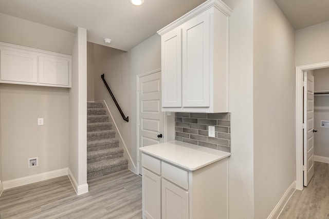 kitchen featuring light hardwood / wood-style floors, tasteful backsplash, and white cabinets