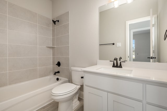 full bathroom featuring vanity, toilet, hardwood / wood-style floors, and tiled shower / bath