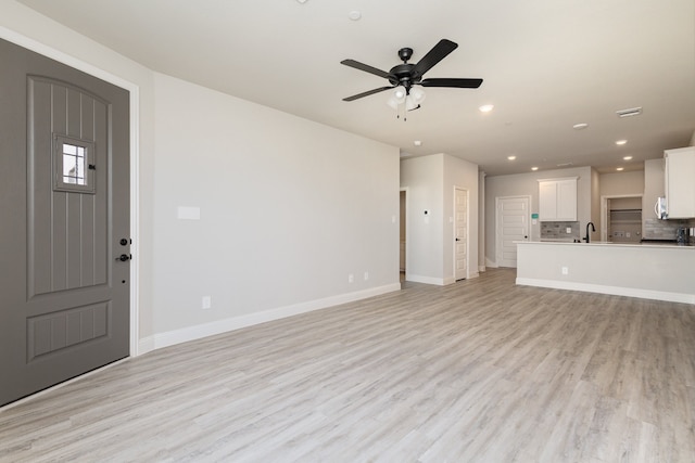 unfurnished living room featuring light hardwood / wood-style floors and ceiling fan