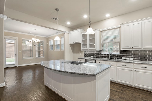 kitchen featuring a healthy amount of sunlight, light stone counters, and white cabinetry