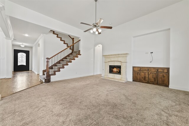 unfurnished living room featuring carpet flooring, ceiling fan, and a premium fireplace