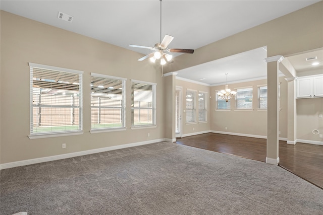 unfurnished living room featuring plenty of natural light, ceiling fan with notable chandelier, dark hardwood / wood-style floors, and ornamental molding