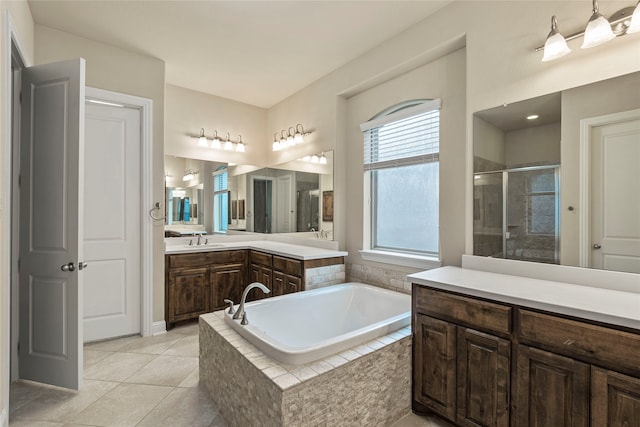 bathroom featuring tile patterned floors, vanity, and shower with separate bathtub