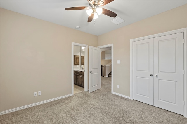 unfurnished bedroom with ceiling fan, light carpet, connected bathroom, and a closet