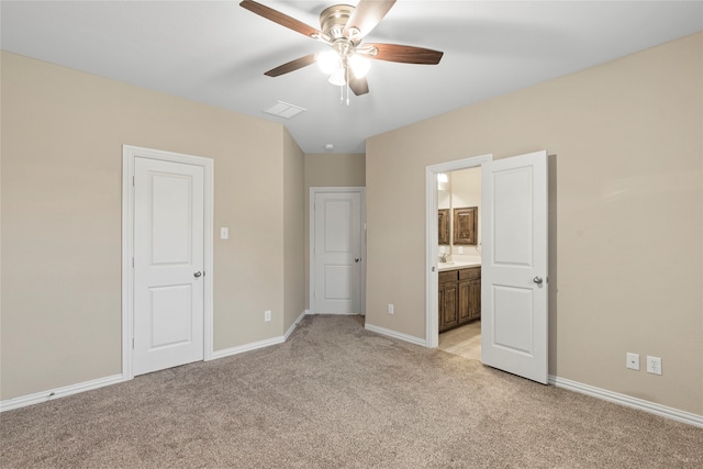 unfurnished bedroom with ceiling fan, light colored carpet, and ensuite bathroom