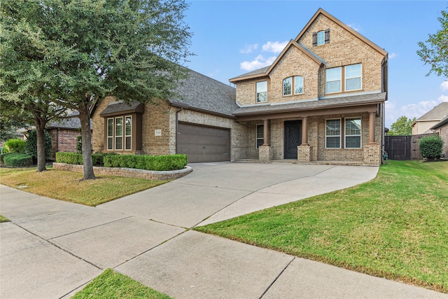 view of front of property with a front yard, a garage, and covered porch