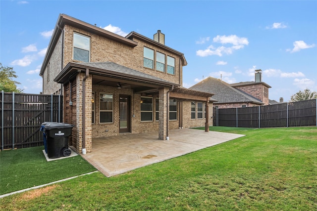 back of house featuring a patio area and a lawn