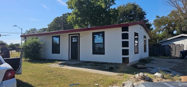 view of front of home with a front yard and fence