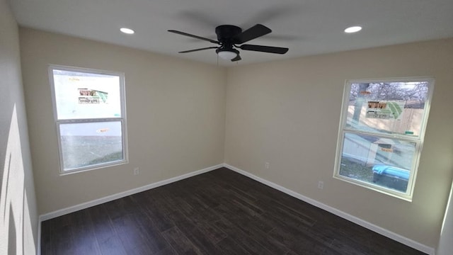 spare room featuring recessed lighting, dark wood-style flooring, plenty of natural light, and baseboards