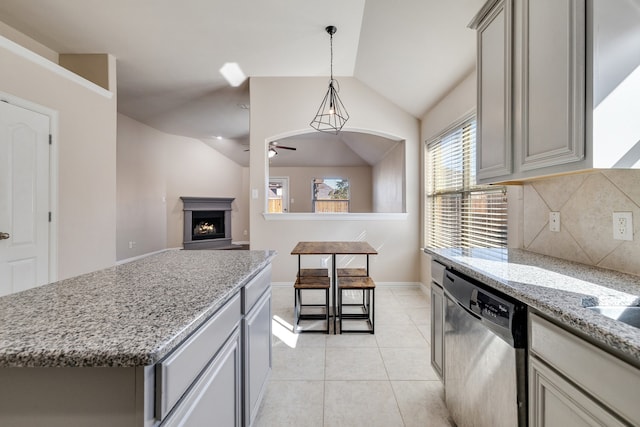 kitchen featuring gray cabinetry, dishwasher, a center island, vaulted ceiling, and decorative backsplash