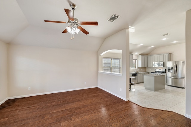 unfurnished living room featuring dark hardwood / wood-style floors, ceiling fan, and lofted ceiling