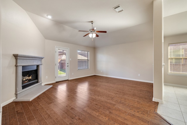 unfurnished living room featuring dark hardwood / wood-style floors, ceiling fan, and vaulted ceiling