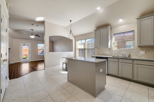 kitchen with decorative backsplash, light stone counters, and light hardwood / wood-style flooring