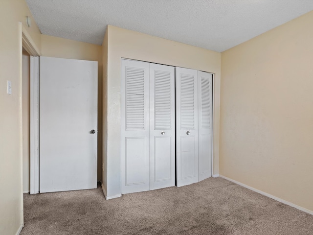 unfurnished bedroom with a closet, a textured ceiling, and carpet