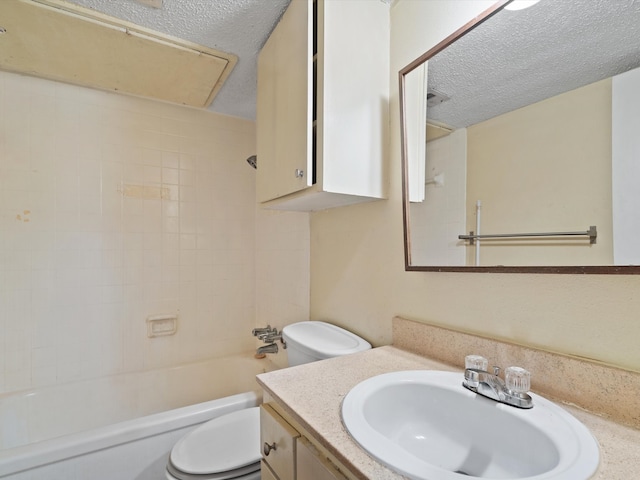 full bathroom with toilet, tiled shower / bath combo, vanity, and a textured ceiling